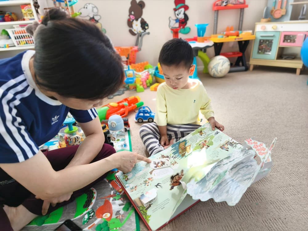 Caregiver reading an interactive book with a toddler