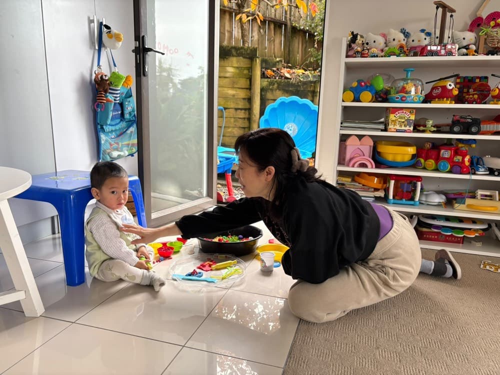 Caregiver leading a hands-on table activity with toddlers