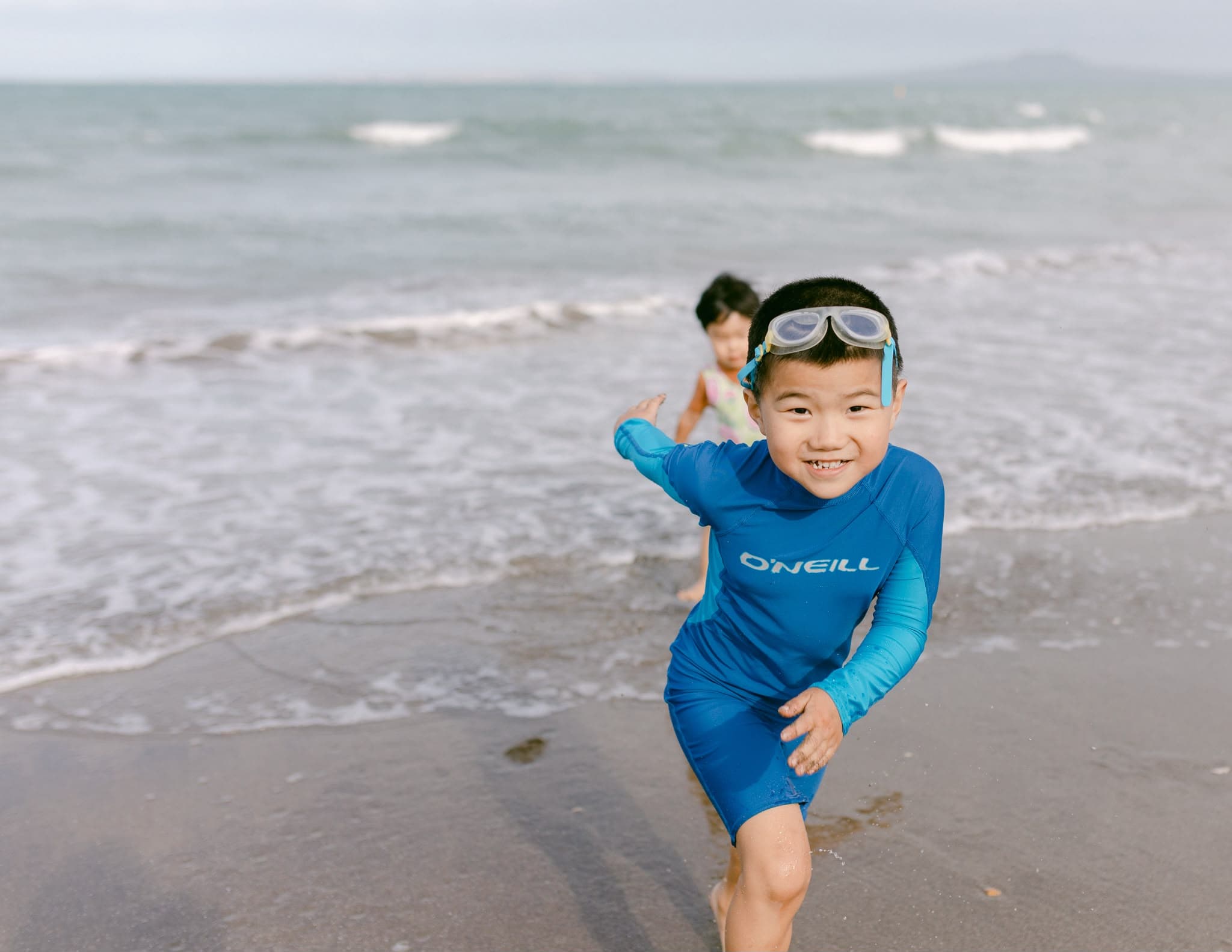 Happy child playing at an Auckland beach